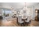 Bright dining area with an elegant chandelier and modern decor adjacent to the living room and kitchen at 9055 Swan River St, Littleton, CO 80125