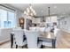 Cozy dining area with seating for six adjacent to a bright modern kitchen with stainless appliances and stone backsplash at 9055 Swan River St, Littleton, CO 80125