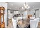Dining room with a modern chandelier, wood table, and seating for six adjacent to a kitchen with granite countertops at 9055 Swan River St, Littleton, CO 80125