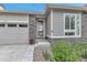 Close up of entrance on single Gathering home with stone facade, a two-car garage, and well maintained yard at 9055 Swan River St, Littleton, CO 80125