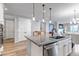 Granite kitchen island with sink and stainless-steel dishwasher overlooking the dining and living area at 9055 Swan River St, Littleton, CO 80125