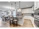 Modern kitchen featuring stainless steel appliances, a large island with bar seating and pendant lighting at 9055 Swan River St, Littleton, CO 80125