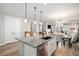 Bright kitchen island with a stainless steel sink, stylish lighting, and an open view to the dining area at 9055 Swan River St, Littleton, CO 80125