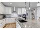 Spacious kitchen featuring granite countertops, white cabinets, stainless-steel appliances, and breakfast bar at 9055 Swan River St, Littleton, CO 80125