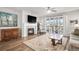 Cozy living room with fireplace, ceiling fan, wood flooring, and sliding glass doors to outdoor living space at 9055 Swan River St, Littleton, CO 80125