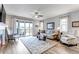 Bright and spacious living room featuring hardwood floors, a ceiling fan, and large sliding glass doors at 9055 Swan River St, Littleton, CO 80125
