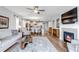 Open-concept living space with fireplace, wood floors, and seamless flow into the dining area and kitchen at 9055 Swan River St, Littleton, CO 80125