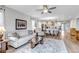 Bright living room open to dining and kitchen offering stylish furnishings, ceiling fan and wood laminate floors at 9055 Swan River St, Littleton, CO 80125