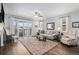 Bright living room with wood flooring, ceiling fan, and sliding glass doors to the outdoor patio at 9055 Swan River St, Littleton, CO 80125