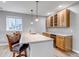 Stylish wet bar with wooden cabinets, marble countertops, barstool seating and pendant lighting at 9055 Swan River St, Littleton, CO 80125