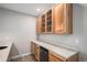 The wet bar features wooden cabinets with glass doors and a mini fridge, perfect for entertaining at 9055 Swan River St, Littleton, CO 80125