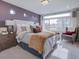 Cozy bedroom showcasing neutral tones, a large window, and comfortable seating at 1176 Sugarloaf Ln, Erie, CO 80516
