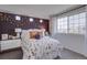 Bedroom with decorative accent wall and large window, creating a cozy and inviting atmosphere at 1176 Sugarloaf Ln, Erie, CO 80516