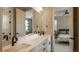 Modern bathroom with double vanity sinks, sleek black hardware, and a view into the adjacent bedroom at 6922 Copper Sky Cir, Castle Pines, CO 80108