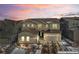 Charming two-story home with stone accents, three car garage, and picturesque landscaping against a colorful sunset sky at 6922 Copper Sky Cir, Castle Pines, CO 80108