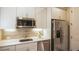 Small kitchen with white cabinets, stainless steel appliances, and tiled backsplash at 6922 Copper Sky Cir, Castle Pines, CO 80108