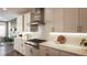 Modern kitchen with white cabinets, gas cooktop, and stainless steel appliances at 6922 Copper Sky Cir, Castle Pines, CO 80108