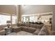 Open-concept living room with a plush sectional sofa, high ceilings, and seamless connection to the modern kitchen at 6922 Copper Sky Cir, Castle Pines, CO 80108
