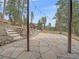 Stone patio and backyard surrounded by tall pine trees and rock wall with stairs at 11093 Milliken Ave, Conifer, CO 80433