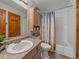 Bathroom featuring a single sink vanity, shower with tub, and wood accents at 11093 Milliken Ave, Conifer, CO 80433
