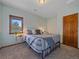 Comfortable bedroom with large window, side table and stylish striped bedding at 11093 Milliken Ave, Conifer, CO 80433