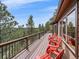 An expansive deck area offers stunning views and features bright red Adirondack chairs at 11093 Milliken Ave, Conifer, CO 80433