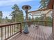 Relaxing deck area with a heater, comfortable seating, and views of a lush, wooded landscape at 11093 Milliken Ave, Conifer, CO 80433