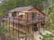 Two-story home featuring a large outdoor deck with seating and overhead shade structure at 11093 Milliken Ave, Conifer, CO 80433