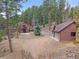 Inviting mountain home with a detached garage surrounded by a lush forest landscape at 11093 Milliken Ave, Conifer, CO 80433