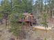 Charming home with multiple decks and a stone patio, surrounded by mature trees at 11093 Milliken Ave, Conifer, CO 80433