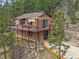 Two-story home featuring a large outdoor deck with seating and overhead shade structure at 11093 Milliken Ave, Conifer, CO 80433