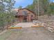 Exterior view of a two-story home with a large patio, balcony, and stone accents at 11093 Milliken Ave, Conifer, CO 80433