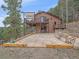 Exterior view of a two-story home featuring a large patio, balcony, and stone accents at 11093 Milliken Ave, Conifer, CO 80433