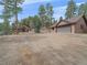 Exterior shot of a beautiful cabin and detached garage surrounded by lush greenery at 11093 Milliken Ave, Conifer, CO 80433