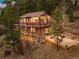 Charming two-story home nestled in the woods with a large patio and string lights at 11093 Milliken Ave, Conifer, CO 80433
