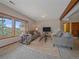 An open-concept living room features cozy sofas, scenic views, and a rustic wooden beam ceiling at 11093 Milliken Ave, Conifer, CO 80433
