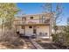 Back exterior featuring a spacious deck, lower patio, and manicured lawn for relaxation and outdoor enjoyment at 7596 Rafter Rd, Franktown, CO 80116