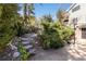 Landscaped backyard features greenery, stone steps, and access to the house with a basketball hoop at 7596 Rafter Rd, Franktown, CO 80116