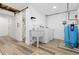 Basement laundry room featuring wood look floors, washer, dryer, sink, and utility equipment at 7596 Rafter Rd, Franktown, CO 80116