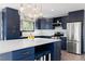 Modern kitchen with blue cabinetry, stainless steel appliances, and white countertops at 7596 Rafter Rd, Franktown, CO 80116