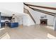 Open-concept living space featuring modern kitchen, staircase and brick fireplace with wood beam accents at 7596 Rafter Rd, Franktown, CO 80116