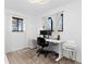 Bright home office with two windows, a modern desk, and neutral decor at 7596 Rafter Rd, Franktown, CO 80116