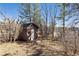 A wooden shed with a white door nestled among trees and foliage at 7596 Rafter Rd, Franktown, CO 80116