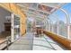 Glass-enclosed sunroom with tiled floors, wood accents and outdoor access to a patio with seating at 7596 Rafter Rd, Franktown, CO 80116
