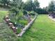 Well-manicured backyard featuring a stone-edged flower garden with vibrant blooms at 6227 Colorow Dr, Morrison, CO 80465