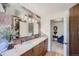 Bathroom showcasing a double vanity, wood cabinets, and view to an adjoining room at 6227 Colorow Dr, Morrison, CO 80465
