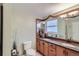Bathroom featuring a double vanity, wood cabinets, and decorative mirror at 6227 Colorow Dr, Morrison, CO 80465