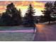 Scenic driveway entrance with lush trees and a colorful sunset at 6227 Colorow Dr, Morrison, CO 80465