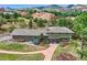 Stunning exterior view of the home, showcasing its brick and siding, lush landscaping, and mountain views at 6227 Colorow Dr, Morrison, CO 80465