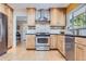 Well-lit kitchen featuring updated appliances, light wood cabinets, and sleek countertops at 6227 Colorow Dr, Morrison, CO 80465